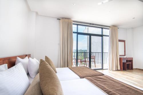 a bedroom with a bed and a large window at Oak Ray Regency in Kandy