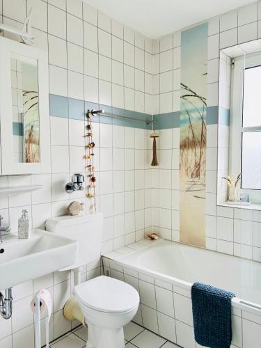 a bathroom with a tub and a toilet and a sink at Ferienwohnung Seelenliebe in Kevelaer