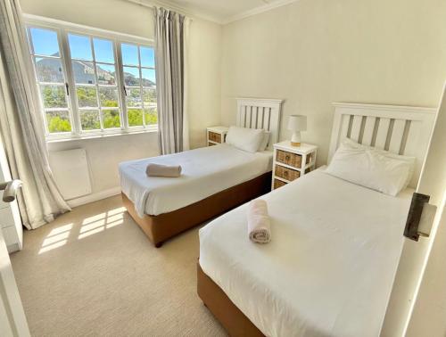 a bedroom with two beds and a window at 8 Settler Sands Ocean View in Port Alfred