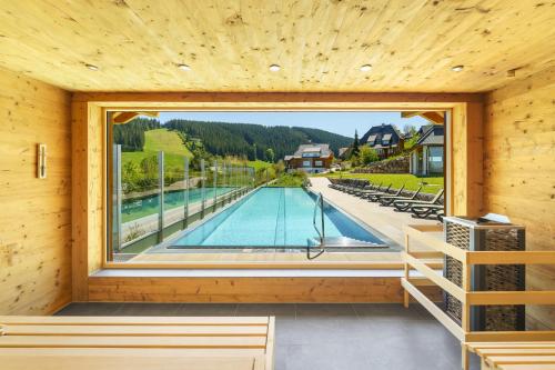 a room with a pool and a large window at Hotel Schlehdorn in Feldberg