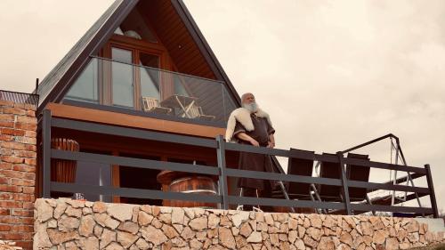 a man standing on the balcony of a house at Mountain house Tomislavgrad with Jacuzzi in Tomislavgrad