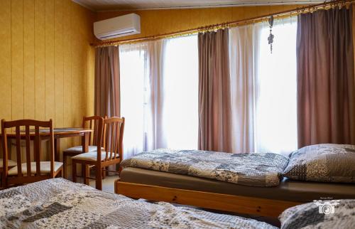 a bedroom with two beds and a table and a window at Domek 57m2 - max 5 osób - NR4 in Ciężkowice