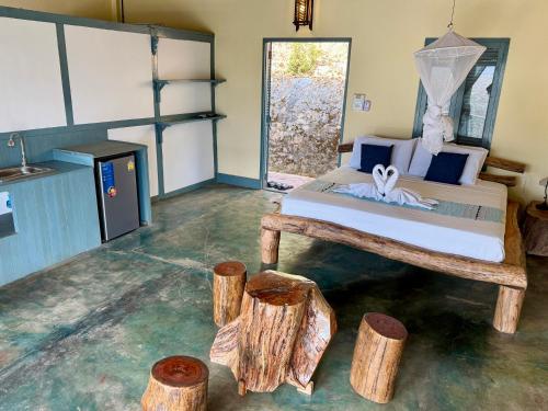 a bedroom with a bed and some logs at Zen Namkhan Boutique Resort in Ban Xianglôm