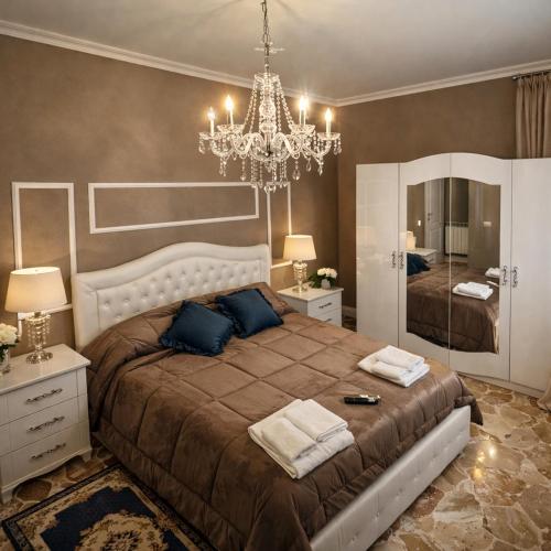 a bedroom with a large bed and a chandelier at Il Castello Di Venere in Rota d'Imagna