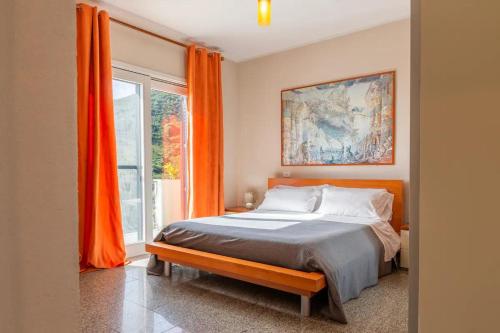 a bedroom with a bed and a window with orange curtains at Villa Terrazza sul Mare in Budoni