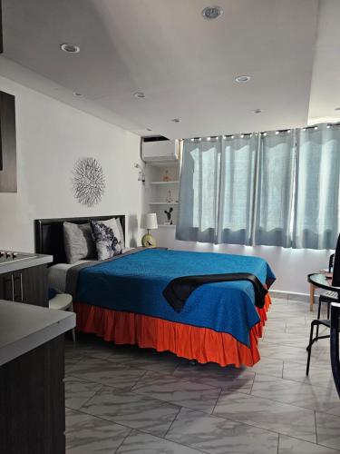a bedroom with a bed with a blue and orange blanket at Sea breeze vacation lll en Condominio Verde mar in San Juan