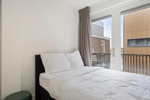 a bedroom with a bed and a balcony at Eindhoven City Suites Hoogstraat B 4P in Eindhoven