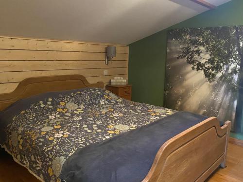 a bedroom with a bed and a painting on the wall at L'île d'Amélie in Ciney