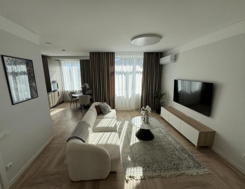a living room with a couch and a tv at City Centre Apartment with Cathedral View, Self Check-in in Šiauliai
