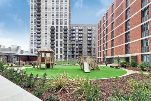 a playground in the middle of a city with tall buildings at Repton Gardens at Wembley Park - Botanical Inspired in London
