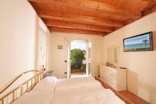 a bedroom with a bed and a dresser and a window at Borgo Del Torchio - Gardagate in Manerba del Garda