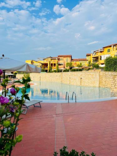 a swimming pool with a bench and some buildings at Borgo Del Torchio - Gardagate in Manerba del Garda