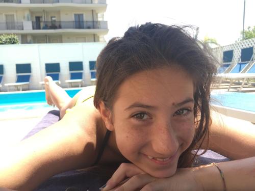 a woman laying on the side of a swimming pool at Hotel Viking in Rimini