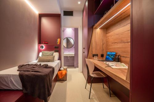 a bedroom with a bed and a desk with a laptop at La 15 Palmera Residence By Soho Boutique in Seville
