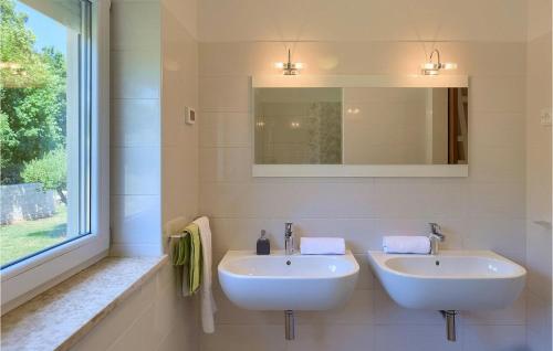 a white bathroom with two sinks and a mirror at Villa Hemera - Oasis of Peace and Privacy by Istrabook in Kršan