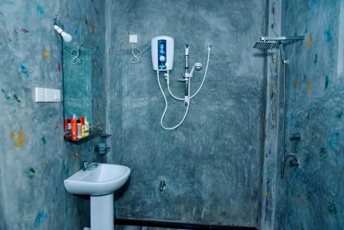 a bathroom with a sink and a phone on the wall at Maiya Wild Ship Villa in Kosgoda