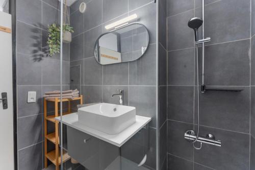a bathroom with a white sink and a mirror at Lilyta B201 in De Haan