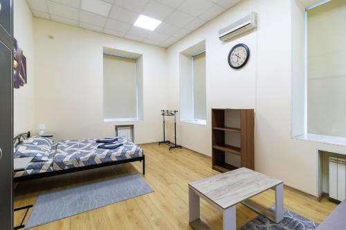 a bedroom with a bed and a clock on a wall at Hostel in the center in Kyiv