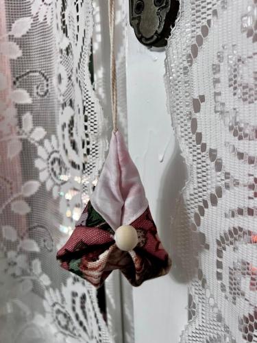 a bird ornament hanging on a window curtain at Kali' in Rapallo