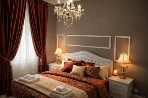 a bedroom with a large bed and a chandelier at Il Borgo del Castello in Rota d'Imagna