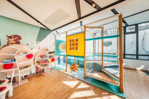 a childrens room with a play area with a large window at Voya Beach Resort - Ultra All Inclusive in Sveti Vlas