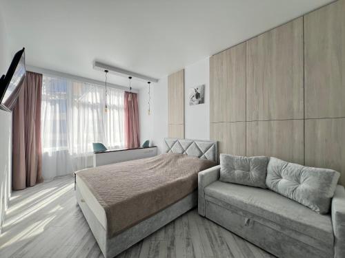 a bedroom with a bed and a couch at Delicious Aparts in Odesa