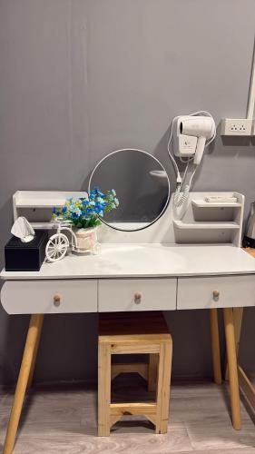a dressing table with a mirror and flowers on it at Y&D Hostel in Bangkok