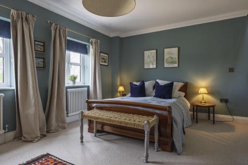a bedroom with a bed with blue walls and a window at Appletree House in Sway