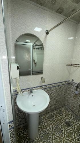 a bathroom with a white sink and a mirror at Alisher hotel in Samarkand