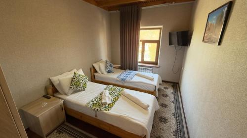 a hotel room with two beds and a window at Alisher hotel in Samarkand