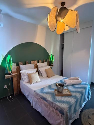 a bedroom with a large bed with a green headboard at Kaz'Baduel piscine, terrasse, wifi et climatisation in Cayenne