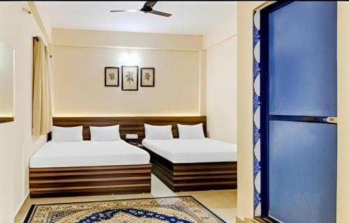two beds in a room with a window at SAI GUEST house in Calangute