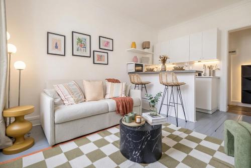 a living room with a couch and a kitchen at FurtiveStay - Les Sablons - Orléans in Neuilly-sur-Seine