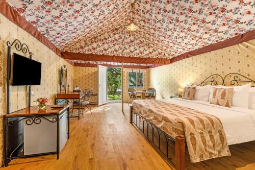 a bedroom with a bed and a tv in a room at Sterling Kanha in Kānha