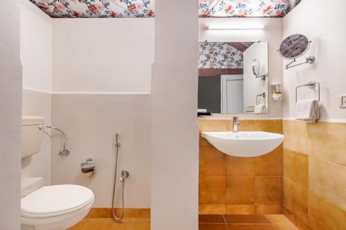 a bathroom with a toilet and a sink at Sterling Kanha in Kānha