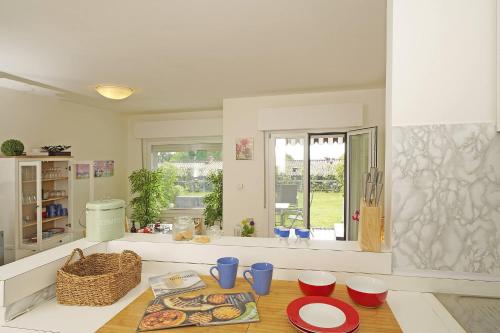 a kitchen with a table with plates and bowls on it at Petronella - Gardagate in Soiano del Lago