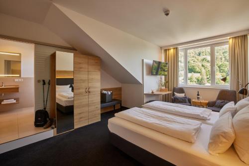 a hotel room with a large bed and a bathroom at Wiedemann's Weinhotel in Sankt Martin