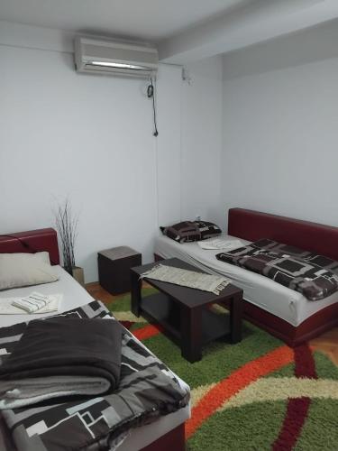 a living room with two beds and a table at Apartment TiBi in Kumanovo