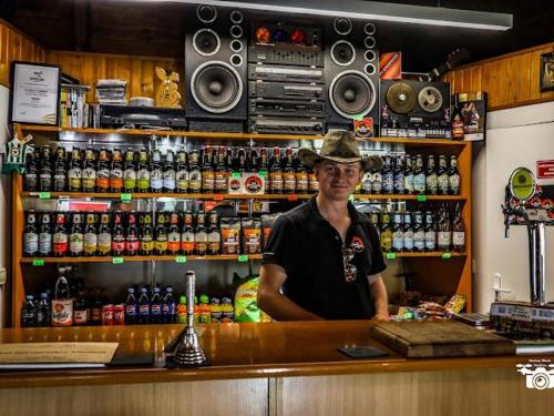 a man is standing behind a counter at a bar at Przyczepa BOHO in Ciężkowice