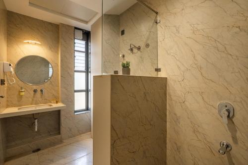a bathroom with a shower and a sink and a mirror at Perfectstayz premium stepwell by the lake in Udaipur