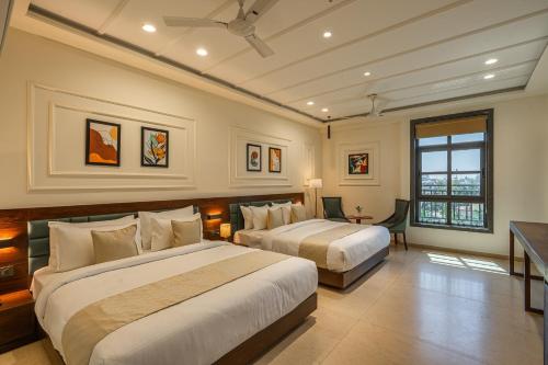 a hotel room with two beds and a window at Perfectstayz premium stepwell by the lake in Udaipur