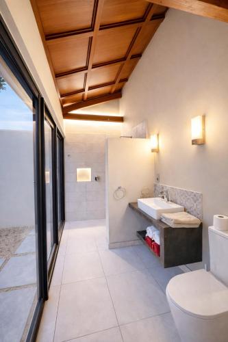 a bathroom with a toilet and a sink at Coconut Lodge Open-Plan Suite with Kitchen, Indoor & Outdoor Showers & Infinity Pool in Cap Malheureux