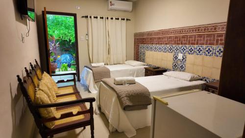 a room with two beds and a table and chairs at Virgínia Palace in Corumbá