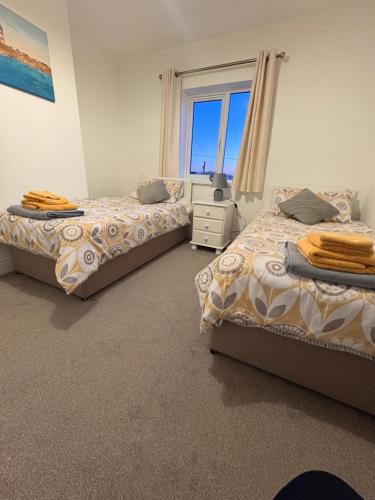 a bedroom with two beds and a window at The Townhouse Dungloe in Dungloe