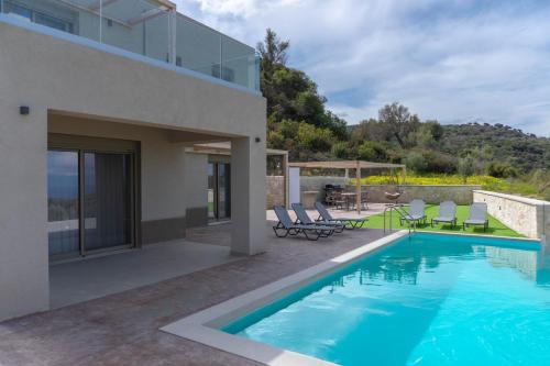 a villa with a swimming pool and a house at Amnia Villas with Private Pool in Kapsalianá