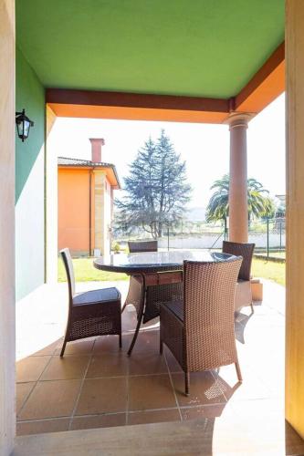 a patio with a table and chairs and a green ceiling at Martinica By Silastur in Ferrera