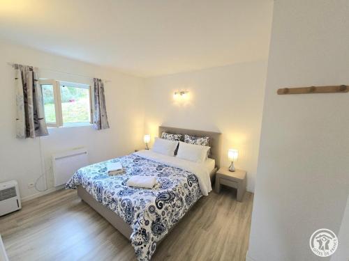 a bedroom with a bed with a blue and white bedspread at Les 3 métisses-lyia in Le Bugue