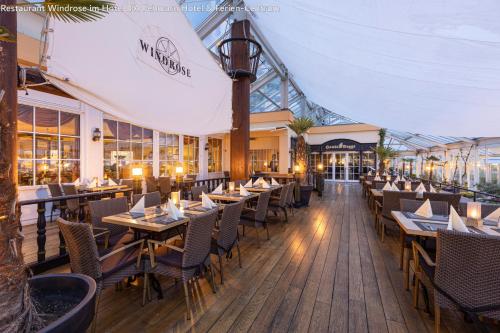 a restaurant with wooden tables and chairs in a building at IFA Yachthafen Fehmarn in Fehmarn