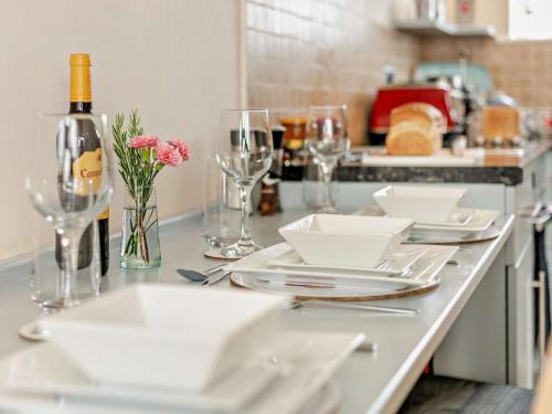 a kitchen counter with white plates and wine glasses at 2 Bed in Helston oc-54556 in Mullion