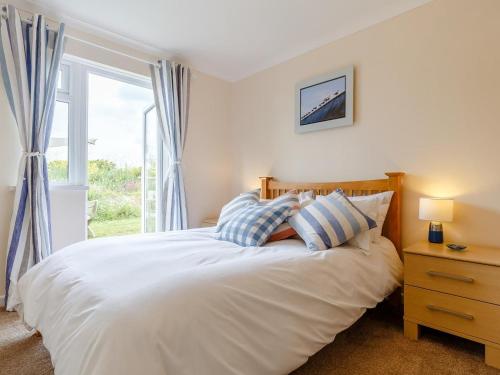 a bedroom with a white bed with a window at 2 Bed in Helston oc-54556 in Mullion